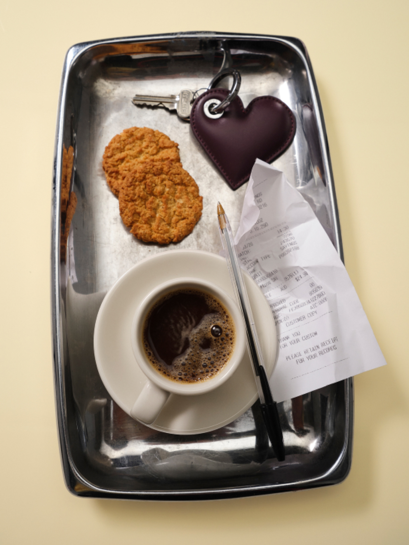 Styled tray with coffee, biscuits and small leather accessories