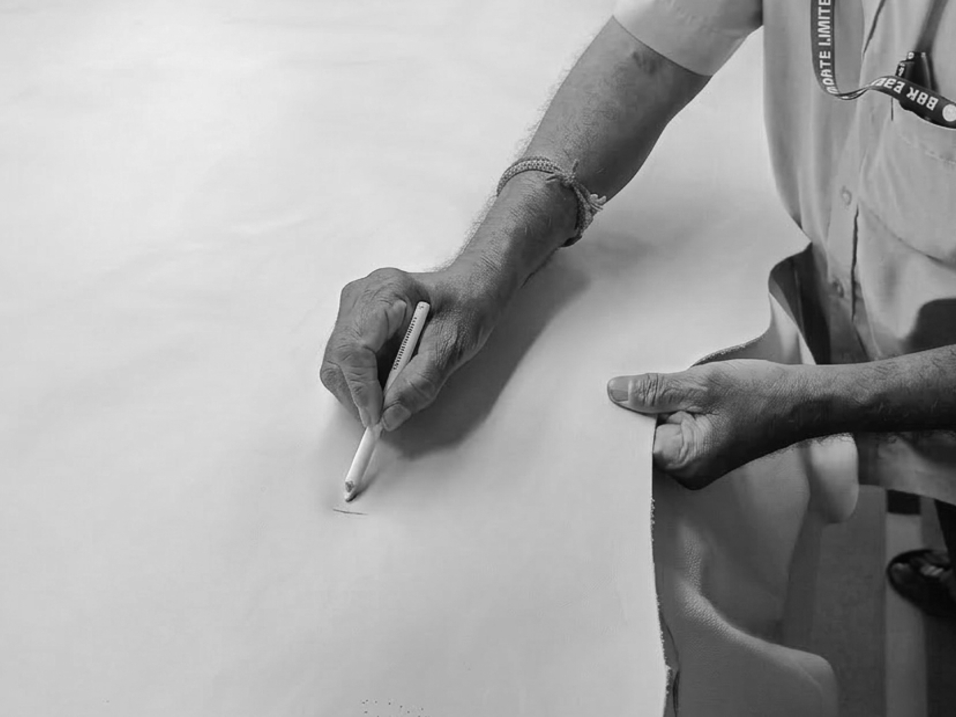 Craftsman marking a leather hide by hand at the workshop table